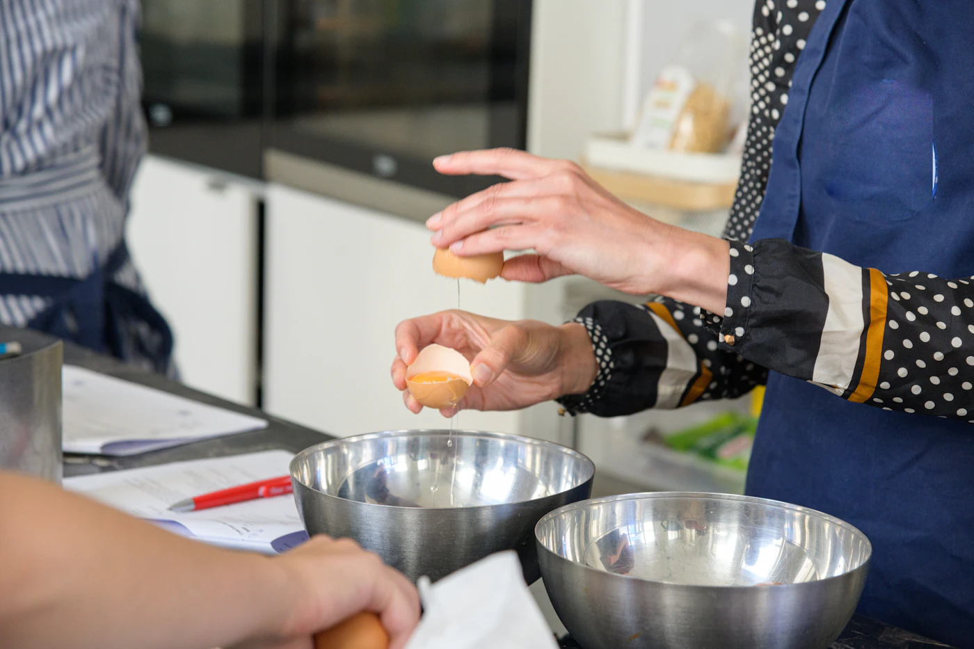 Two home cooks preparing eggs together in a bright kitchen